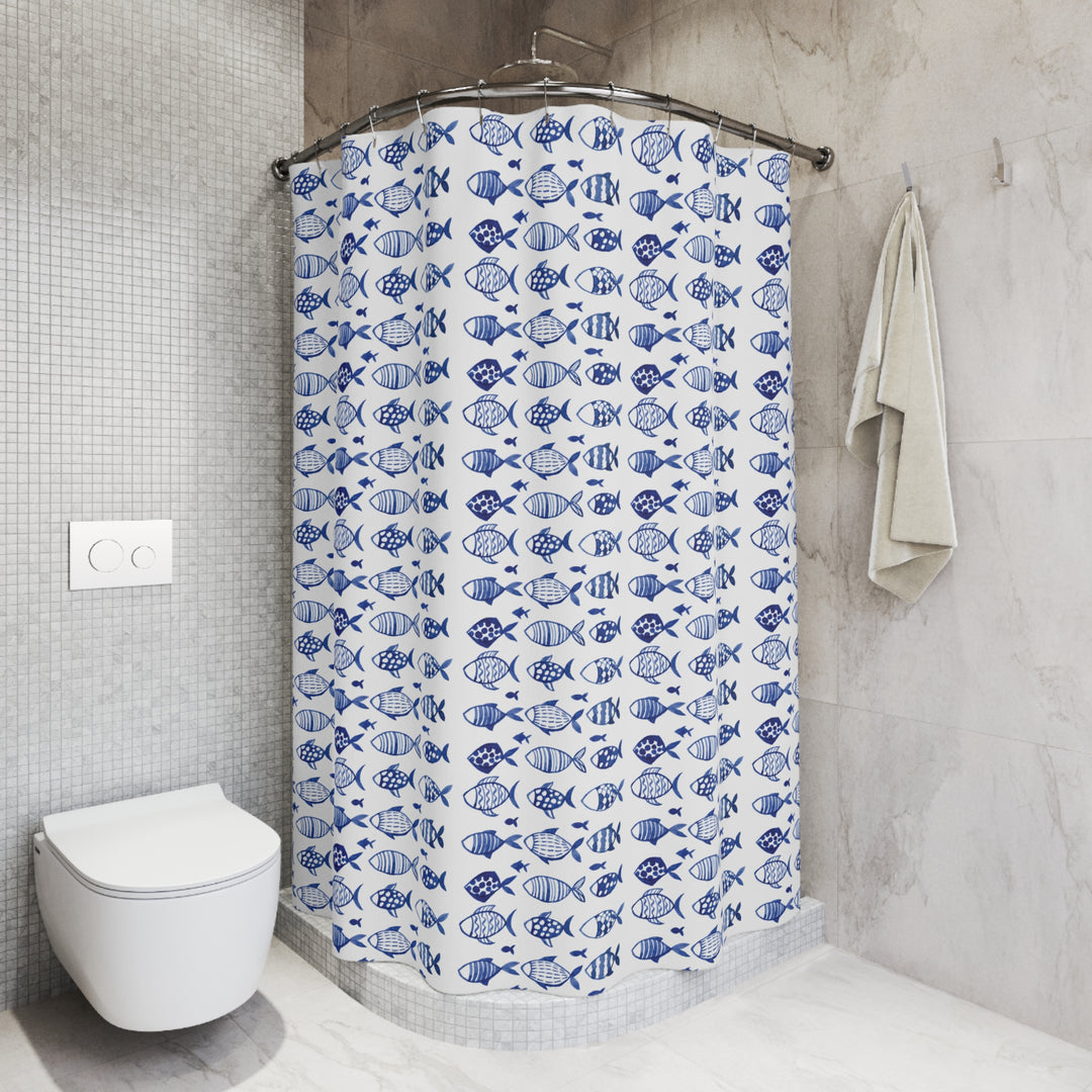 Blue and white fish-pattern shower curtain styled in a sleek, tiled bathroom with a neutral color palette and modern fixtures.