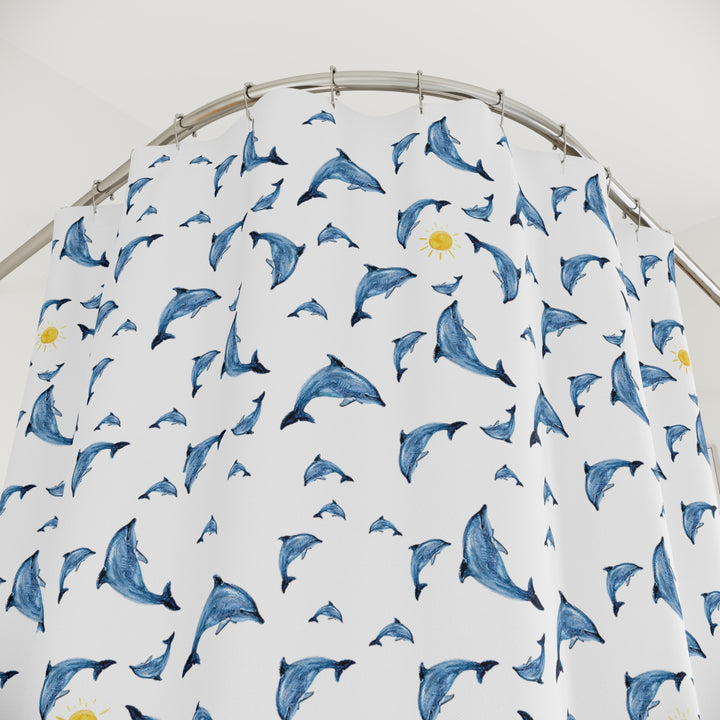 Close-up of a dolphin-patterned shower curtain showcasing its vibrant blue dolphins and cheerful yellow suns on durable polyester fabric, highlighting the whimsical design.