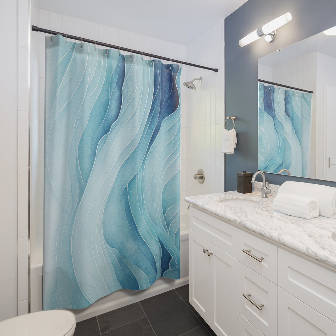 Abstract wave-pattern shower curtain hanging in a contemporary bathroom with a marble countertop, white cabinetry, and a navy accent wall, adding a serene ocean-inspired touch.
